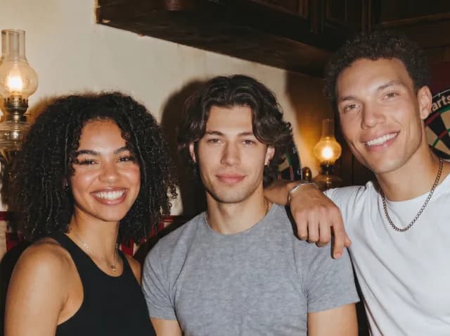 Three new friends smiling together at a bar