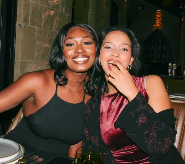 Two friends laughing together over dinner