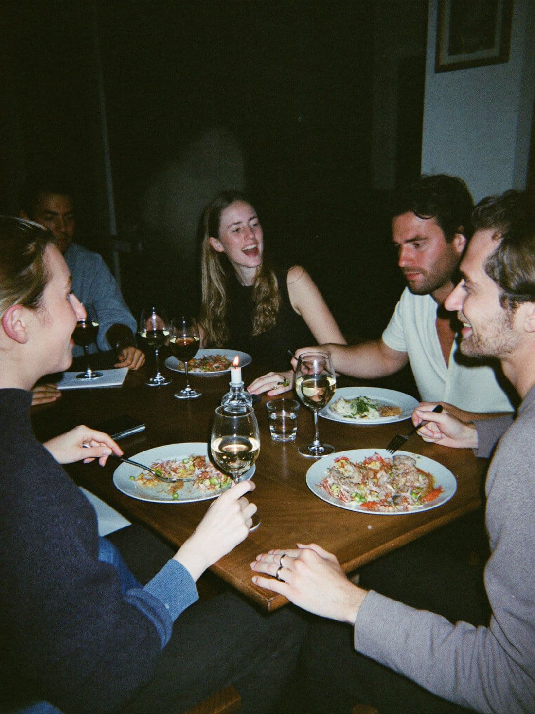 A small group laughing over dinner