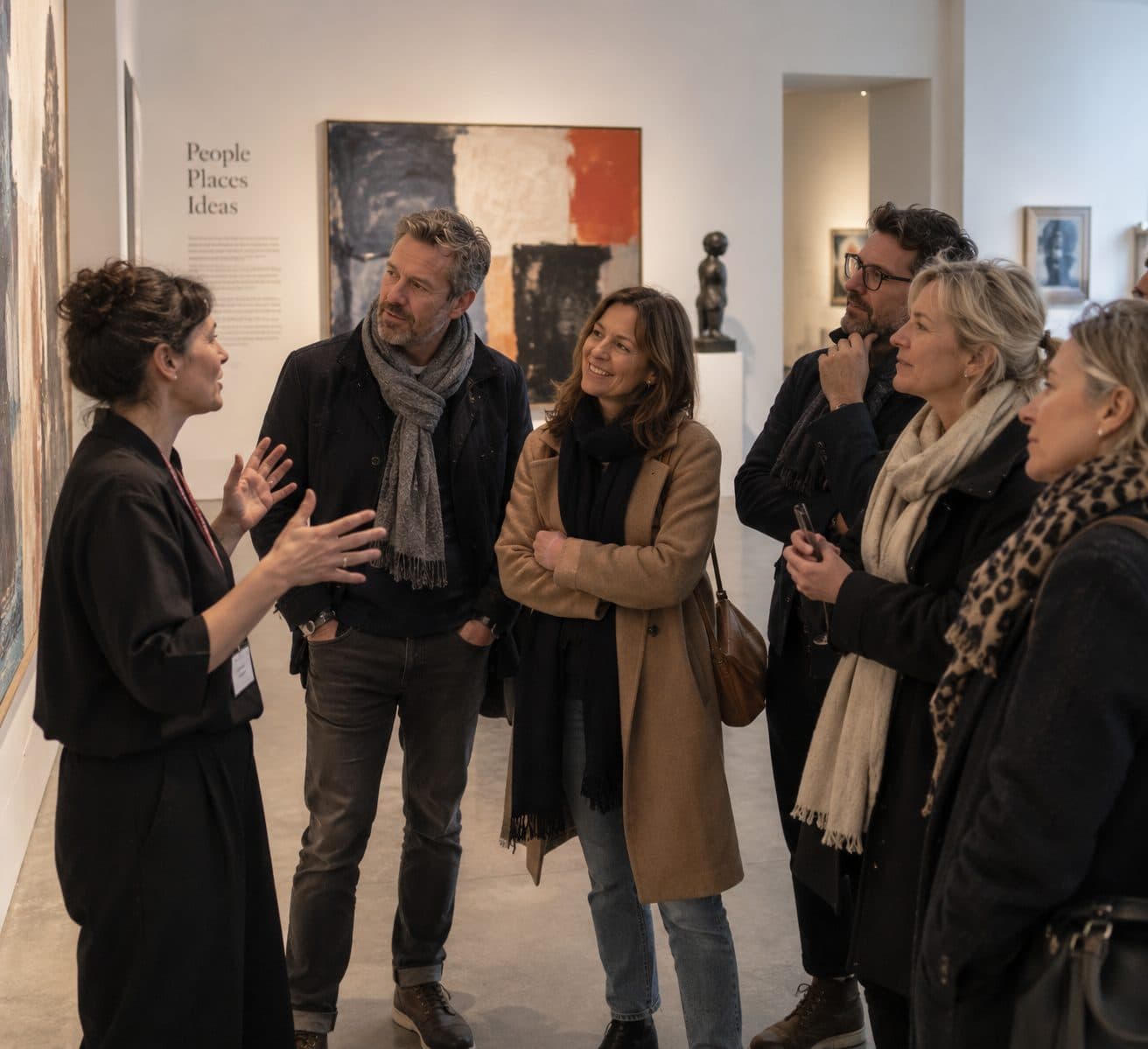 A gallery director talking a small group through a painting