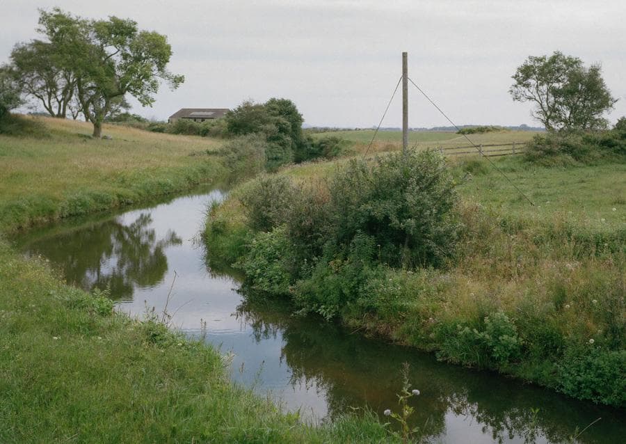 The river winding between green meadows