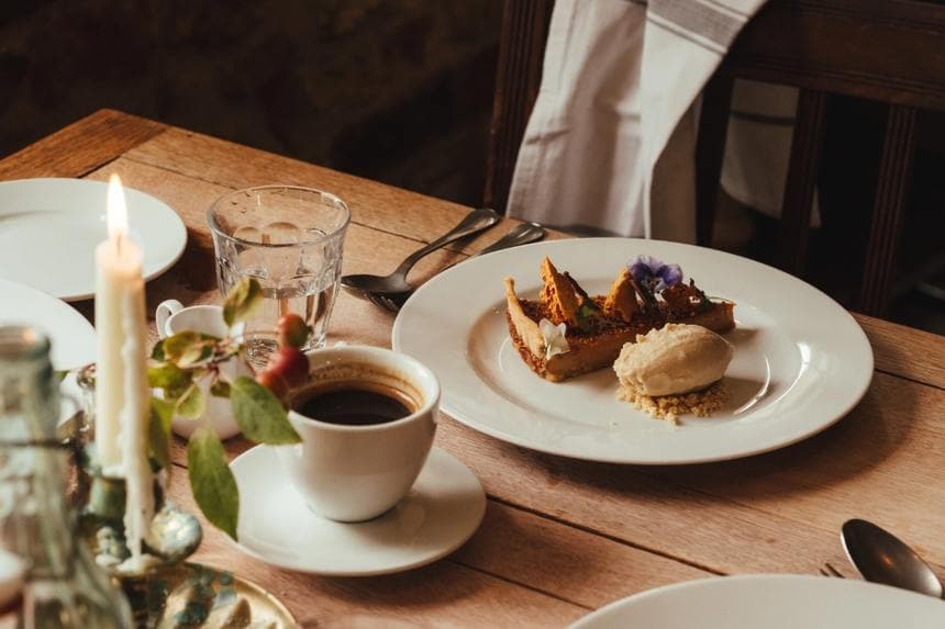 Tart and ice cream with coffee, lit by a candle