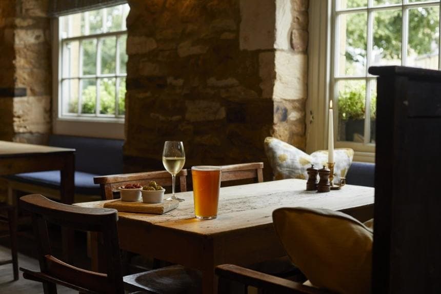 A window table set with drinks and olives