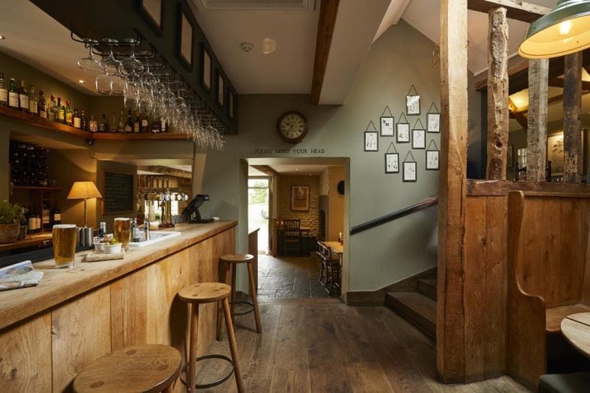 The wooden bar with glasses hanging above it