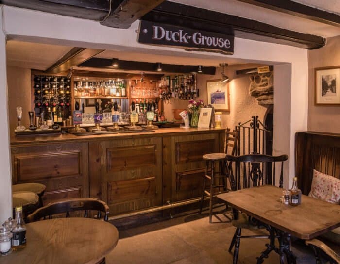 The old wooden bar, with stools and a table by the window