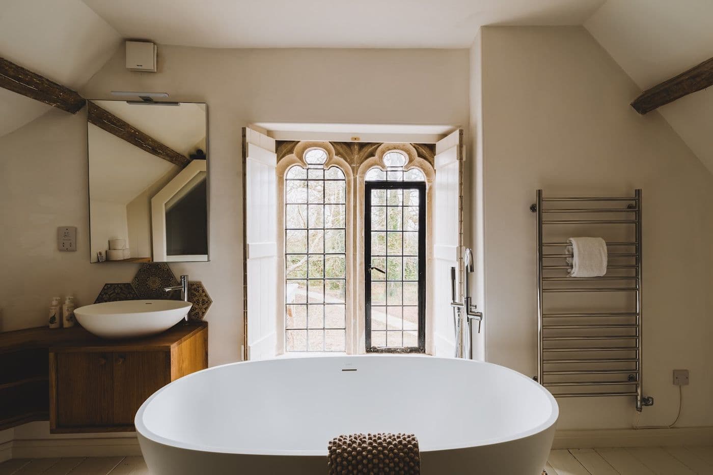 A freestanding bath under the arched window